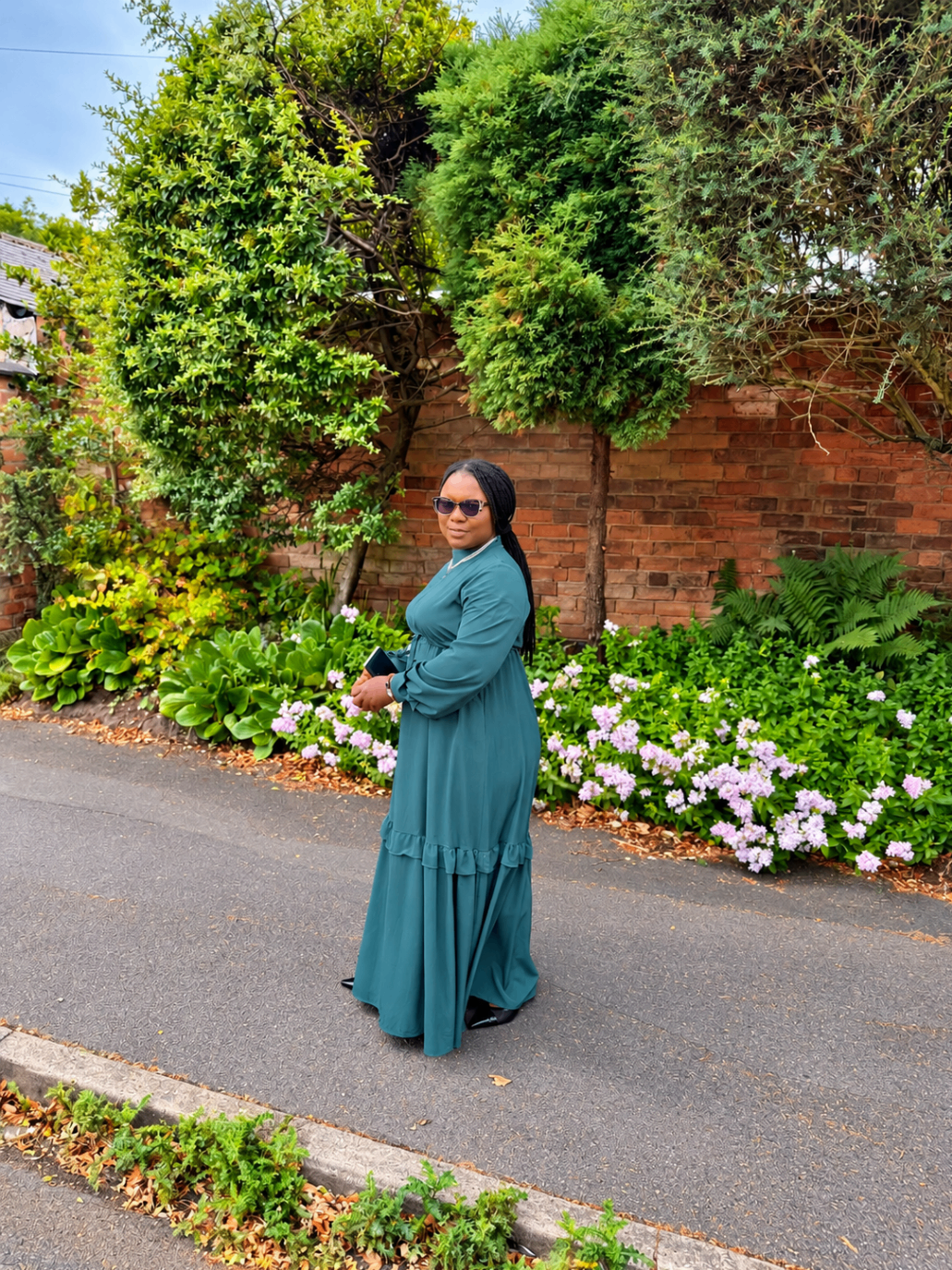 Esther in an emerald dress in a flower garden